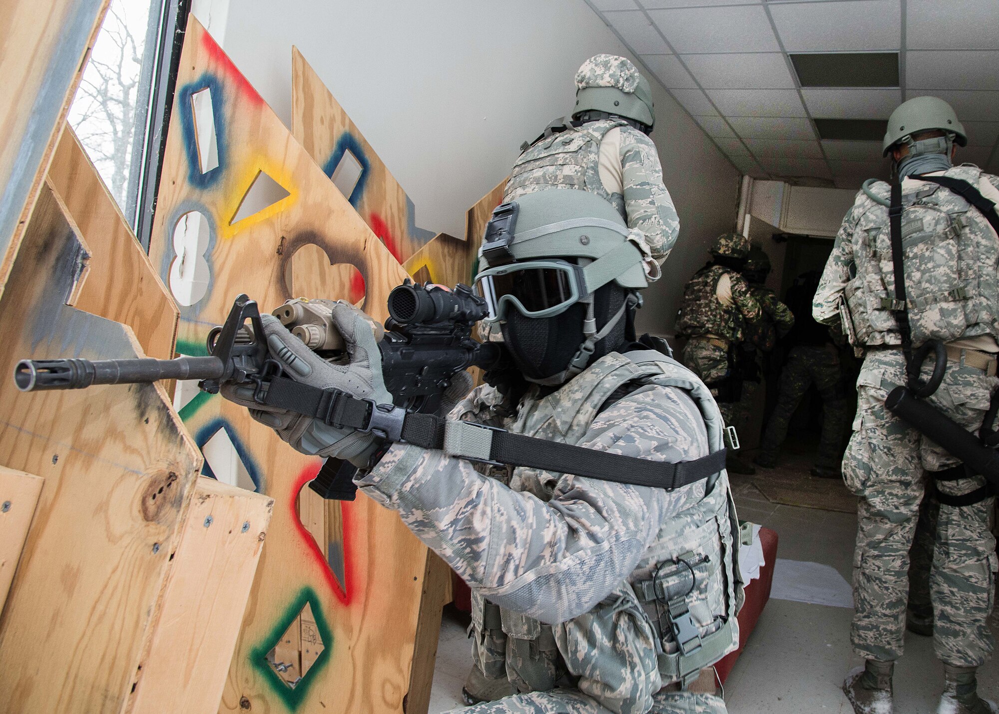 Senior Airman Nicholas Wright, 66th Security Forces Squadron Special Response Team member, supports other team members as they enter an unoccupied building at Hanscom Air Force Base, Mass., during a bimonthly training exercise Jan. 22. The specialized teams operate similar to a civilian Special Weapons and Tactics, or SWAT, team, and must be ready at a moment's notice. (U.S. Air Force photo by Mark Herlihy)