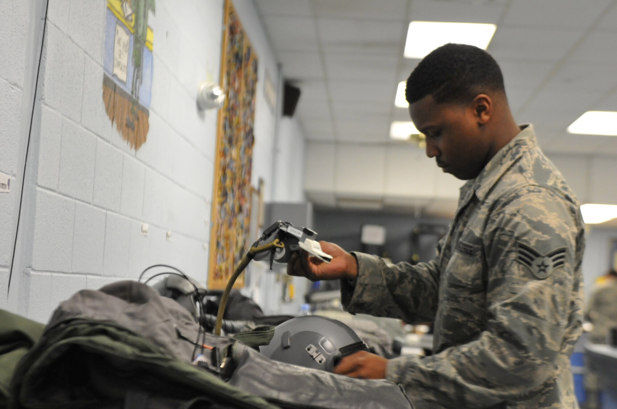 Senior Airman K'Shawn Joseph, 113th Operations Group Aircrew Flight Equipment technician, prepares pilots' equipment prior to a Familiarization Flight at Naval Air Station Joint Reserve Base New Orleans, La. The D.C. Air National Guard Airmen are participating in a two-week flying exercise titled Sentry Voodoo in New Orleans. (Air National Guard photo by Senior Airman Erica Rodriguez/Released)