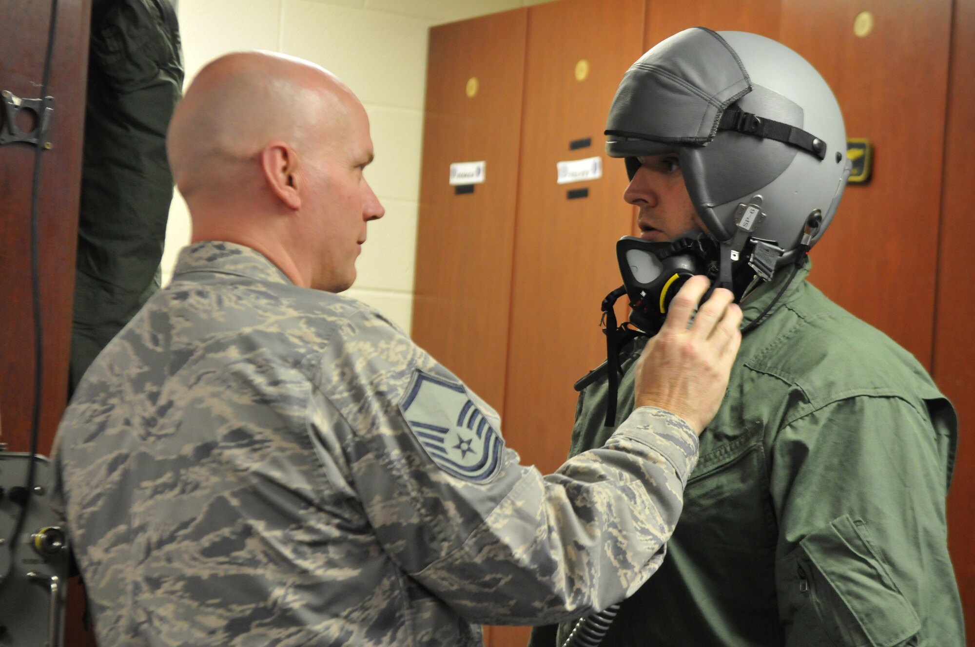 Master Sgt. Steve Johnson, Deployed Aircrew Flight Equipment NCO in Charge, 113th Operations Group, adjusts the mask-fitting on Master Sgt. Kevin Atkins, 113th Wing weather forecaster, prior to a Familiarization Flight at Naval Air Station Joint Reserve Base New Orleans, La. The D.C. Air National Guard Airmen are participating in a two-week flying exercise titled Sentry Voodoo in New Orleans. (Air National Guard photo by Senior Airman Erica Rodriguez/Released)