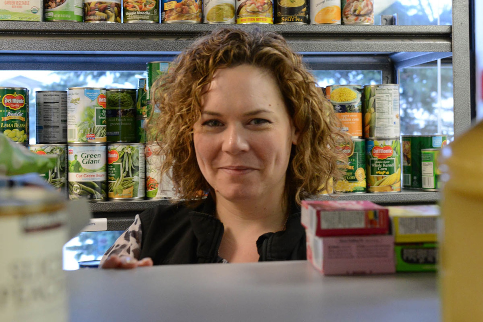 Lita McClain, marketing and public relations specialist for the Armed Services YMCA of Alaska, stocks available shelf space at the ASYMCA food pantry on Joint Base Elmendorf-Richardson, Alaska, Jan. 26, 2016. The food pantry is one of more than 20 programs offered by the ASYMCA, specifically designed to meet the needs of the JBER community. (U.S. Air Force photo by Airman 1st Class Javier Alvarez)

