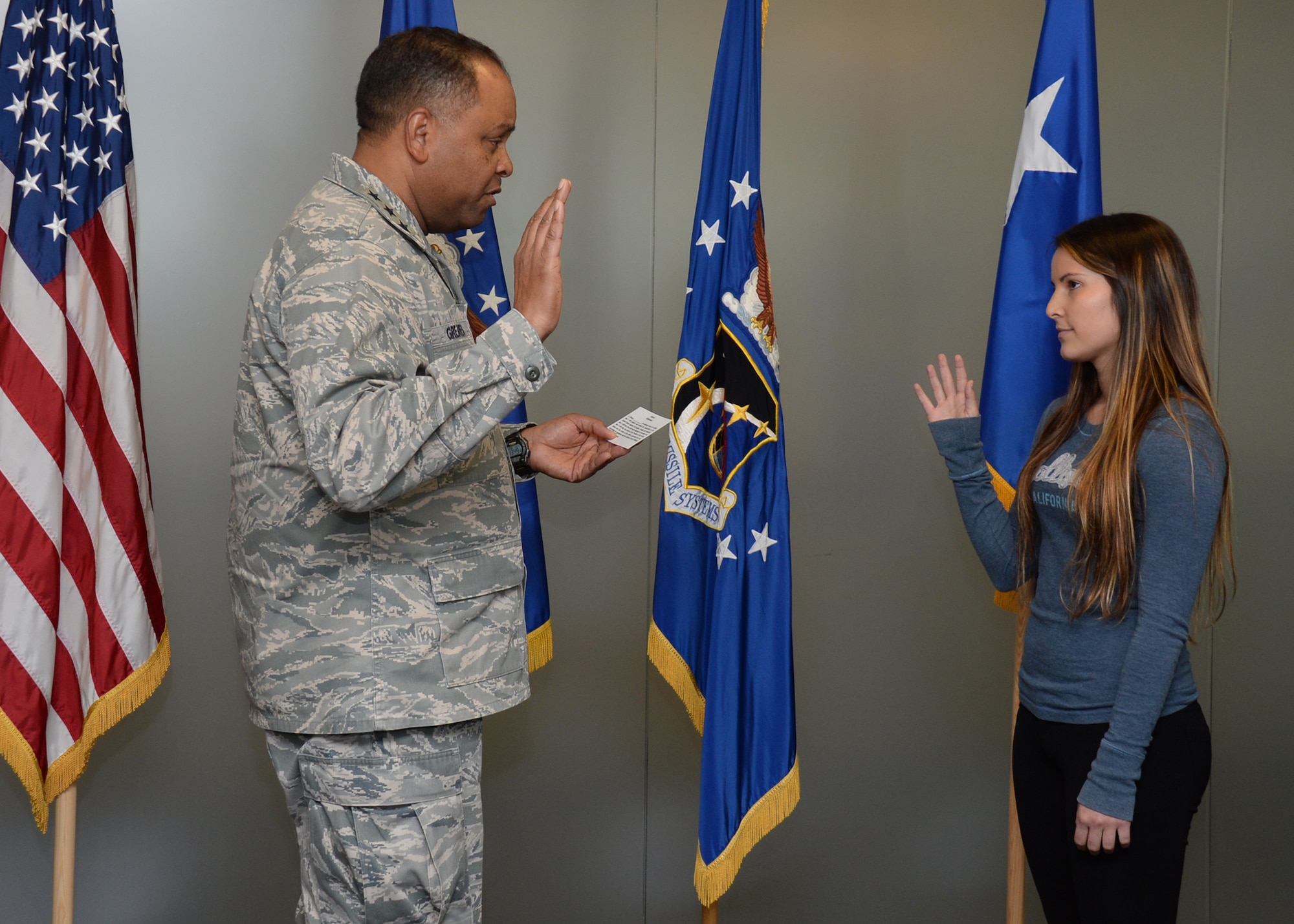 Lt. Gen. Samuel Greaves, Space and Missile Systems Center commander and Air Force program executive officer for space, conducts an impromptu swearing-in ceremony with Air Force Reserve recruit Jennie Ines. The event transpired as the result of a chance meeting the previous December by the Exchange at Los Angeles Air Force Base in El Segundo, Calif. (U.S. Air Force photo/Van Ha)