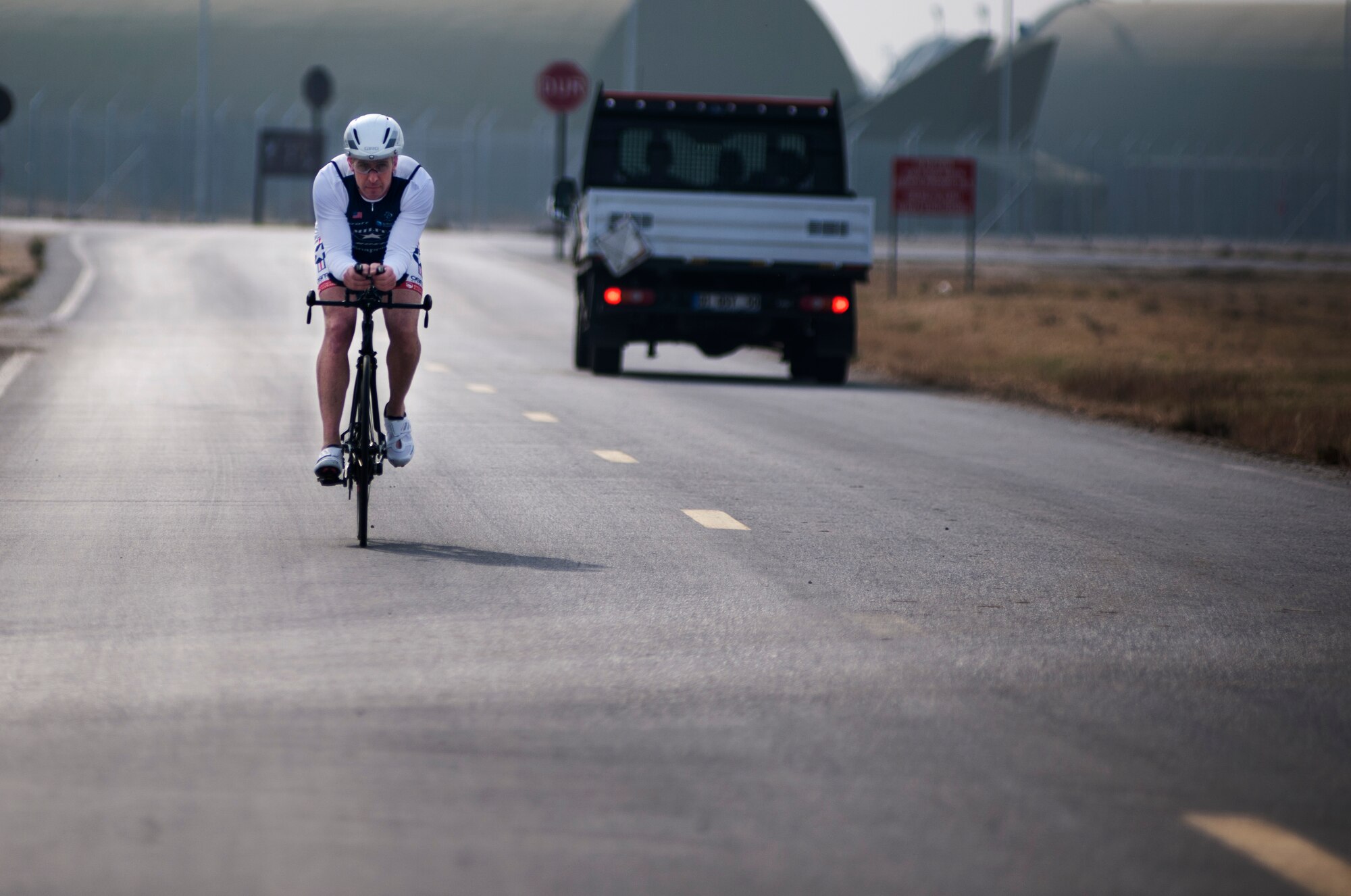 U.S. Air Force Senior Master Sgt. Jason Chiasson, 39th Communications Squadron production superintendent, rides around the flightline Dec. 10, 2015, at Incirlik Air Base, Turkey. Chiasson rode 25 miles on his lunch break as part of his training program for the Air Force Cycling Team. (U.S. Air Force photo by Senior Airman Krystal Ardrey/Released)
