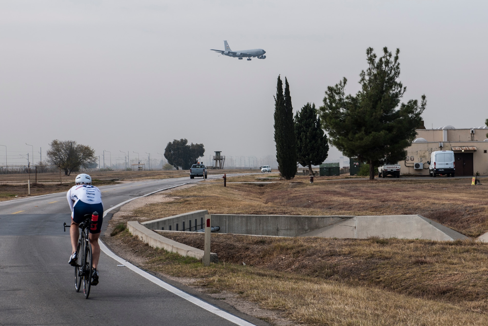 U.S. Air Force Senior Master Sgt. Jason Chiasson, 39th Communications Squadron production superintendent, rides past the flightline Dec. 10, 2015, at Incirlik Air Base, Turkey. Chiasson, a member of the Air Force Cycling Team, regularly cycles a variety distances both indoors and outdoors to stay prepared for the races he will participate in as part of the cycling team. (U.S. Air Force photo by Senior Airman Krystal Ardrey/Released)