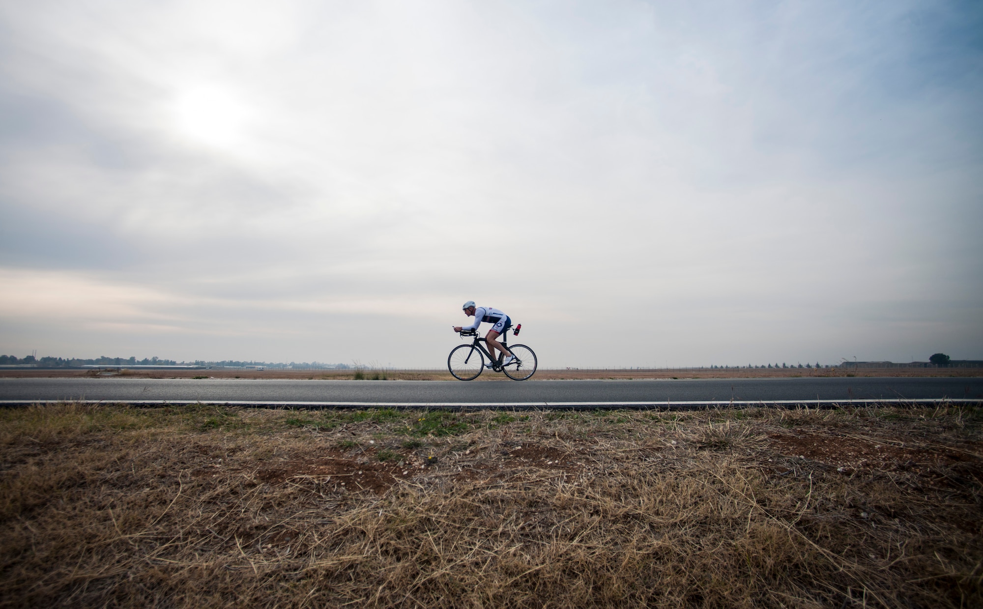 U.S. Air Force Senior Master Sgt. Jason Chiasson, 39th Communications Squadron production superintendent, rides around the flightline Dec. 10, 2015, at Incirlik Air Base, Turkey. Chiasson rode 25 miles on his lunch break as part of his training program for the Air Force Cycling Team. (U.S. Air Force photo by Senior Airman Krystal Ardrey/Released)