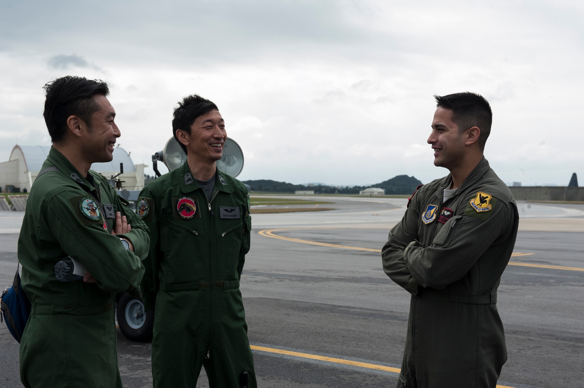 U.S. Air Force Staff Sgt. Chance Italiano, 909th Air Refueling Squadron instructor boom operator and boom flight scheduler, talks with Japan Air Self Defense Force Master Sgts. Koichiro Naka and Masaaki Takahashi, 404th ARS boom operators, during a tour Jan. 22, 2016, at Kadena Air Base, Japan. This meeting allowed them to converse about the differences and similarities of their work. (U.S. Air Force photo by Airman 1st Class Lynette M. Rolen)