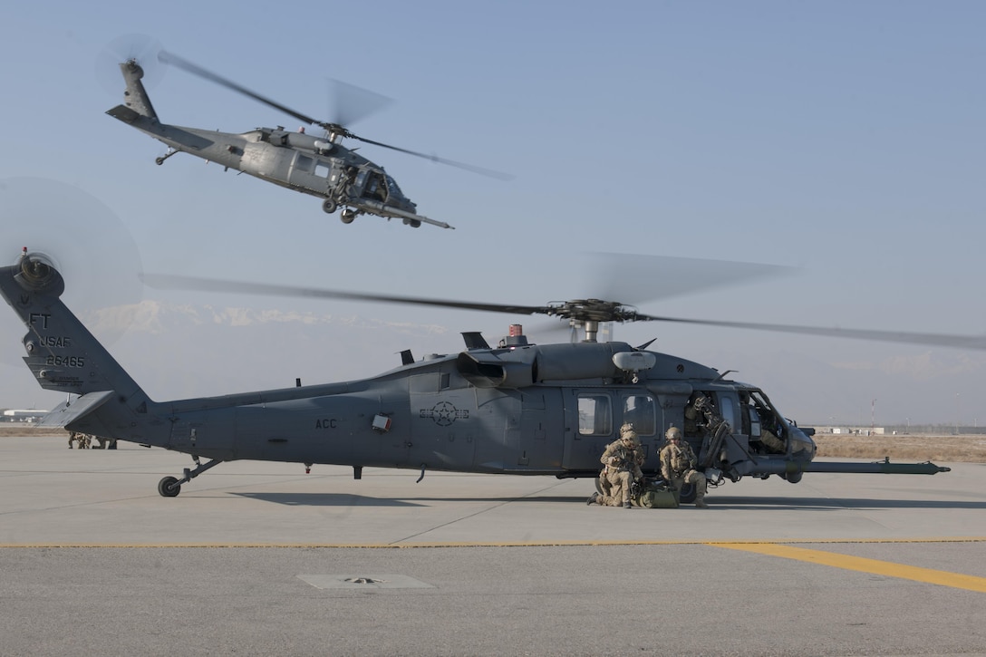 An Air Force HH-60G Pave Hawk helicopter takes off while pararescuemen prepare their gear during an extrication exercise on Bagram Airfield, Afghanistan, Jan. 23, 2016. Air Force photo by Tech. Sgt. Robert Cloys