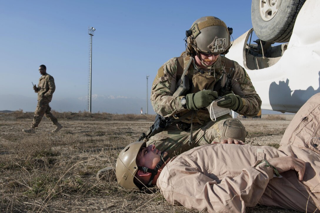 An Air Force pararescueman checks on Air Force Brig. Gen. Dave Julazadeh, 455th Air Expeditionary Wing commander, as he role-plays a casualty in an extrication exercise on Bagram Airfield, Afghanistan, Jan. 23, 2016. Air Force photo by Tech. Sgt. Robert Cloys