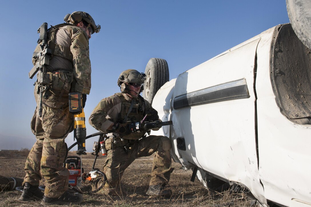 Air Force pararescuemen work to remove the door of a wrecked vehicle and free a simulated casualty during an extrication exercise on Bagram Airfield, Afghanistan, Jan. 23, 2016. Air Force photo by Tech. Sgt. Robert Cloys