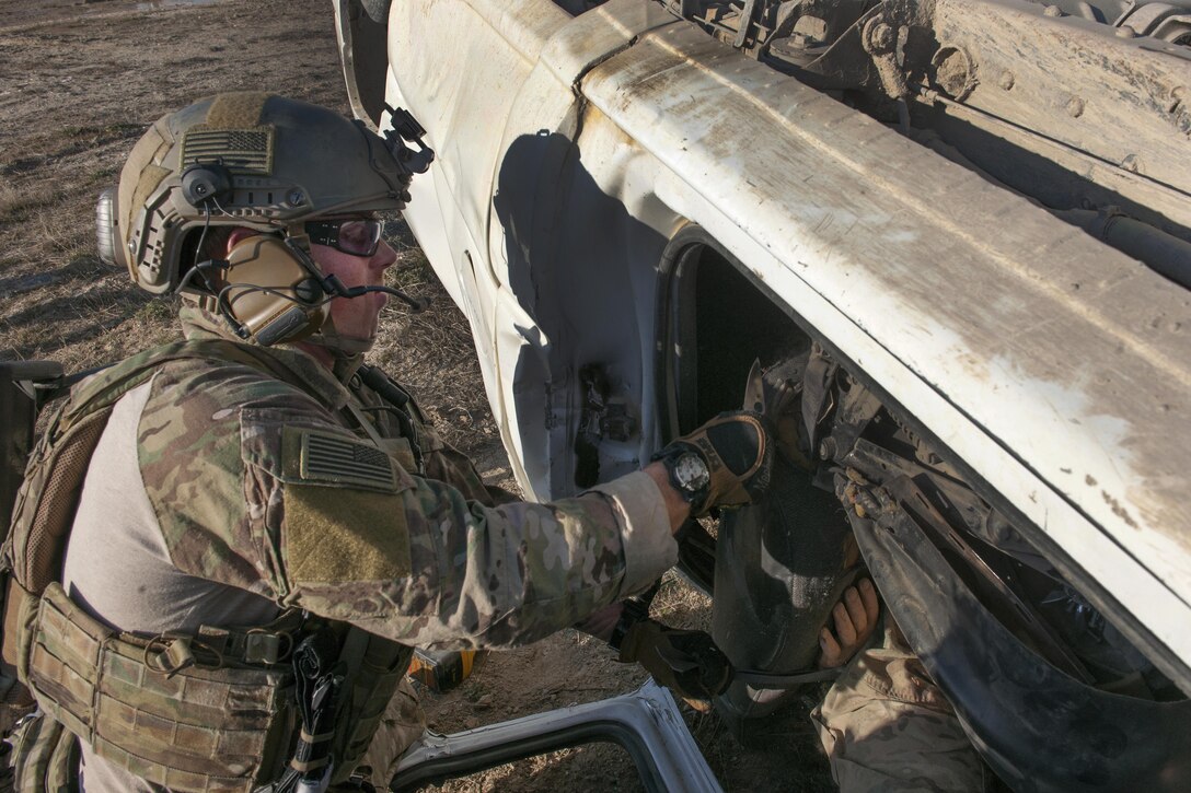An Air Force pararescueman removes part of a vehicle seat to free a mock casualty during an extrication exercise on Bagram Airfield, Afghanistan, Jan. 23, 2016. Air Force photo by Tech. Sgt. Robert Cloys