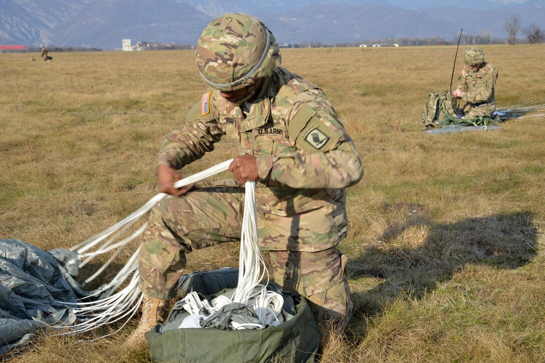 Army Spc. Willie Parker recovers his parachute after an airborne operation from a U.S. Air Force C-130 Hercules aircraft over Juliet drop zone in Pordenone, Italy, Jan. 20, 2016. Parker is a paratrooper assigned to the 54th Brigade Engineer Battalion, 173rd Airborne Brigade. U.S. Army photo by Davide Dalla Massara