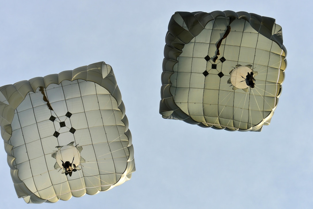 Army paratroopers descend through the sky and prepare to land after exiting a U.S. Air Force C-130 Hercules aircraft during an airborne operation over Juliet drop zone in Pordenone, Italy, Jan. 20, 2016. U.S. Army photo by Davide Dalla Massara