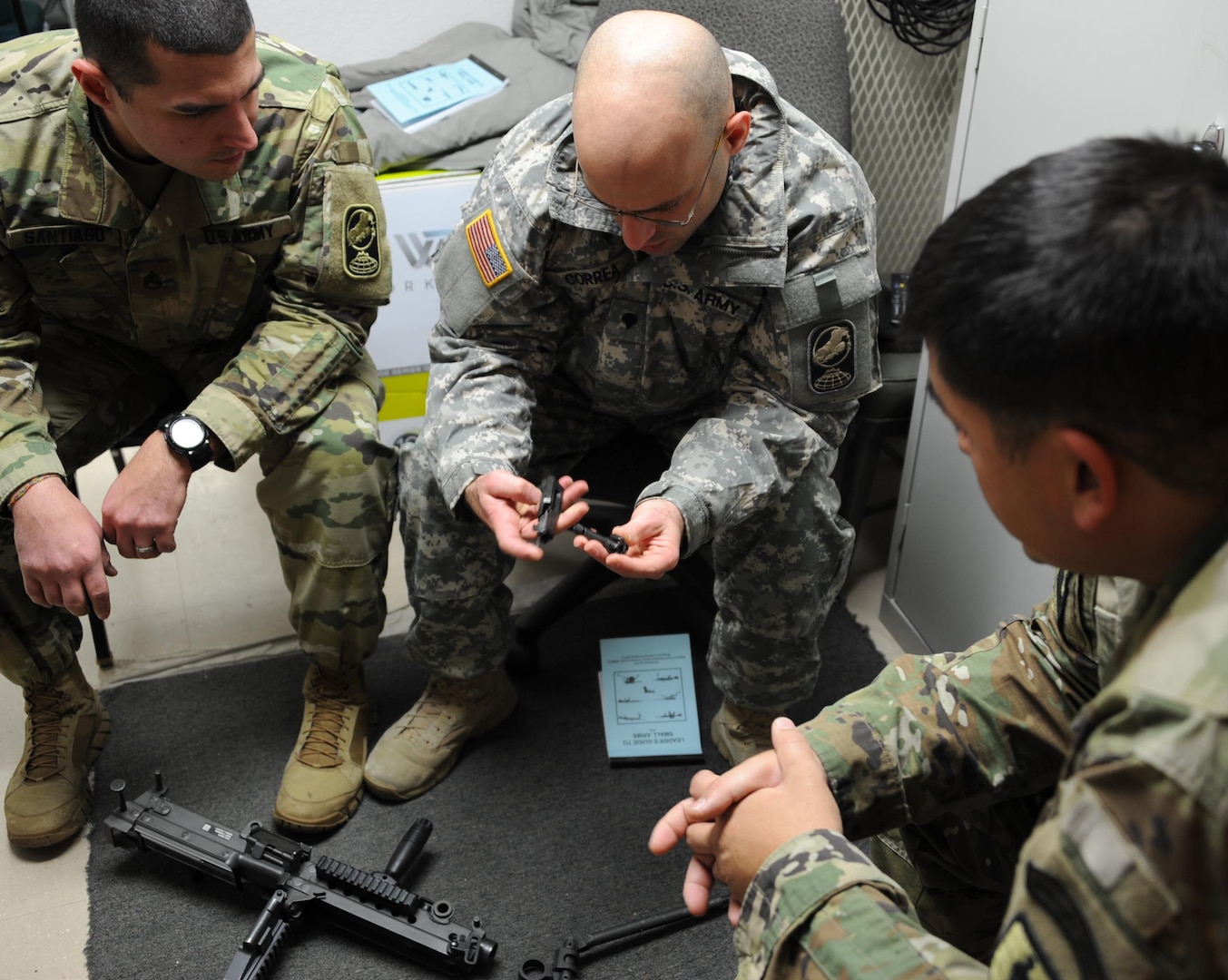 Sgt. 1st Class Richard Stanley, National Guard Marksmanship Training Center small arms trainer, instructs two students on the mechanics of the M249 Squad Automatic Weapon during a Small Arms Weapons Expert course held at Fort Greely, Alaska, in December 2015.