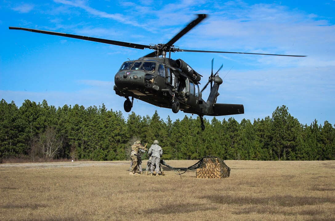 Paratroopers prepare to connect a cargo net of supplies to a UH-60 Black Hawk helicopter during slingload training on Fort Bragg, N.C., Jan. 20, 2016. Army photo by Sgt. Chad Haling