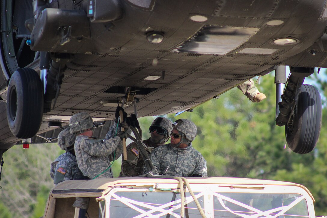 Paratroopers connect a Humvee to a UH-60 Black Hawk helicopter during slingload training on Fort Bragg, N.C., Jan. 20, 2016. Army photo by Sgt. Chad Haling