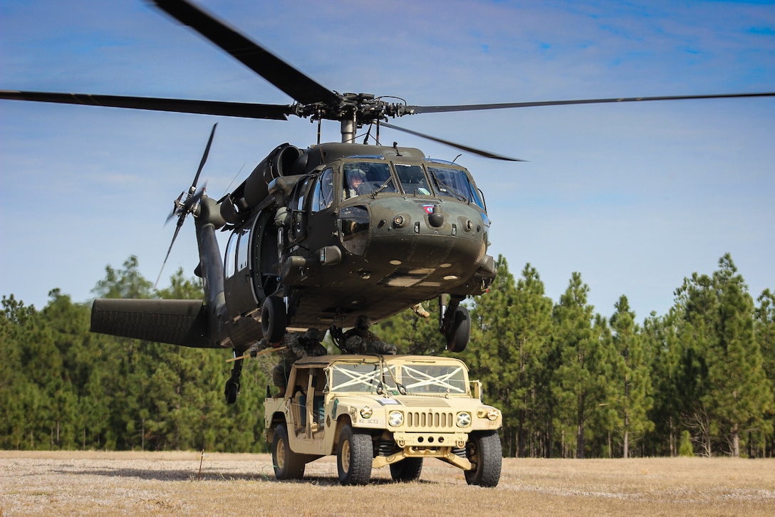 Paratroopers finish connecting a Humvee to a UH-60 Black Hawk helicopter during slingload training on Fort Bragg, N.C., Jan. 20, 2016. Army photo by Sgt. Chad Haling