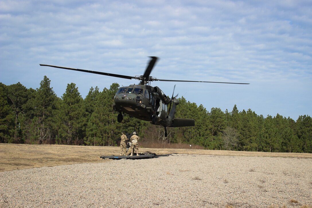 Paratroopers prepare to connect a flat rack to a UH-60 Black Hawk helicopter during slingload training on Fort Bragg, N.C., Jan. 20, 2016. Army photo by Sgt. Chad Haling