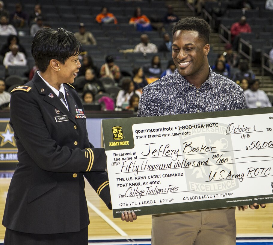 Col. Easter Sharpe, Warrior Transition Unit director, U.S. Army Reserve Command, congratulates Jeffery Booker after awarding him a scholarship worth $50,000 at the Time Warner Cable Arena during the 2015 CIAA basketball tournament held annually in Charlotte, N.C. Sharpe was one of a handful of Army Reserve Soldiers on hand at the event to tout the rewards and benefits of military service through the Army Reserve. (U.S. Army Photo by Sgt. 1st Class Brian Hamilton)