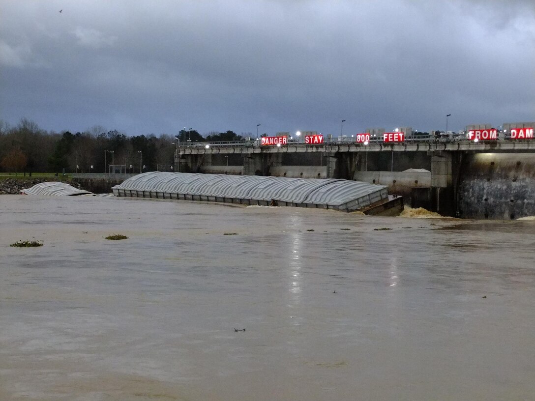 Barge 1 on top of barge 2 against spillway gate.