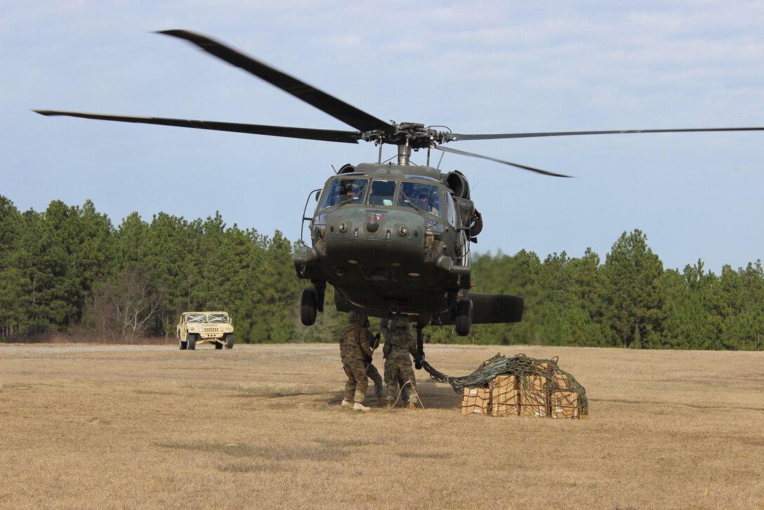 Paratroopers connect a cargo net of supplies to a UH-60 Black Hawk helicopter during slingload training on Fort Bragg, N.C., Jan. 20, 2016. Army photo by Sgt. Chad Haling