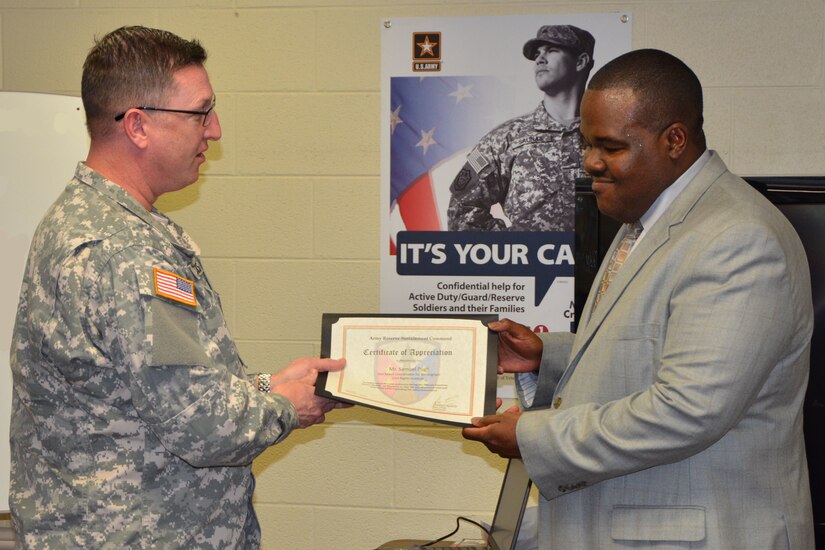 Maj. Steven Francis, HHD commander with the Army Reserve Sustainment Command (ARSC), presents Samuel Pugh with a certificate of appreciation for his powerful presentation during the ARSC’s Black History Program.