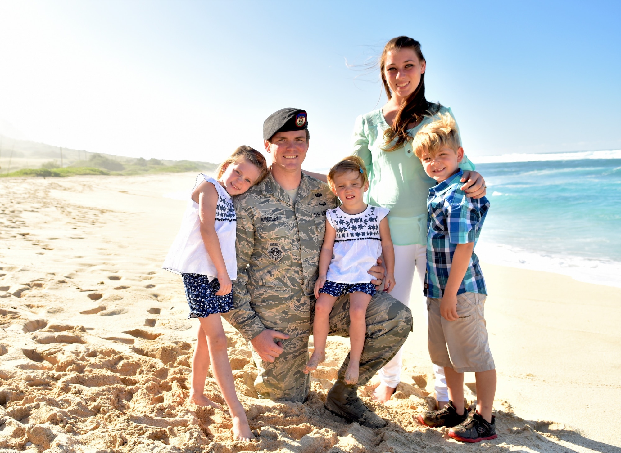 Staff Sgt. John Kinsley III, JTAC weapons officer, 25th Air Support Operations Squadron, poses with his family at Dillingham Beach, Waialua, Hawaii, Jan. 21, 2016. Kinsley rescued a kayaker on Jan. 18, swimming more than 150-feet off shore, traversing waves ranging from 10 to 15 feet. (U.S. Air Force photo by Staff Sgt. Christopher Stoltz)