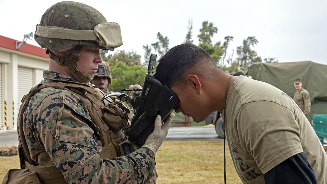A Marine uses a Biometric Enrollment Screening Device to take an iris scan of a role player during a noncombatant evacuation operation training exercise Jan. 21, 2016 at Camp Hansen, Okinawa, Japan. Marines and sailors with Combat Logistics Battalion 31, 31st Marine Expeditionary Unit, conducted the training as part of Marine Expeditionary Unit Exercise II, a pre-deployment training exercise designed to prepare them for their upcoming spring deployment. The BESD is a handheld portable device that collects and stores biometric information.