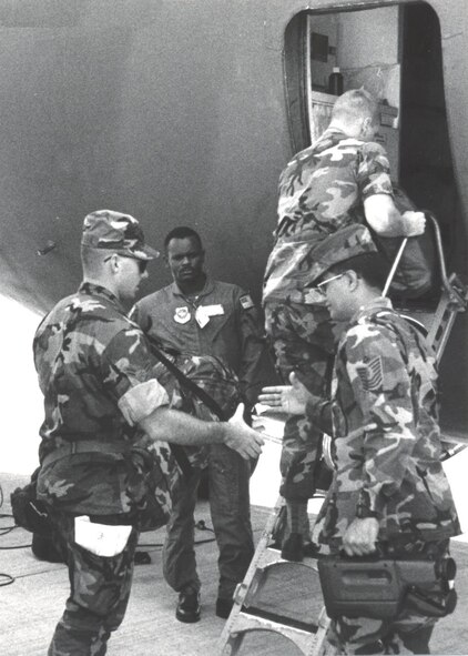 Deploying members of the 15th Security PoliceSquadron shake hands with their first sergeant,MSgt Wesley B. Ke, before climbing aboard the C-141which carried them on the first leg of their longjourney to Saudi Arabia. (courtesy photo)