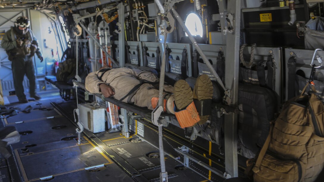 A Marine preparing to deploy with the 31st Marine Expeditionary Unit lies on a litter after being brought onto an MV-22B Osprey with Marine Medium Tiltrotor Squadron 161 during casualty-evacuation training at Marine Corps Base Camp Pendleton, California, Jan. 20. Casualty-evacuation training prepares the Marines to land in a combat zone, pick up injured Marines and transport them to a safe area.
