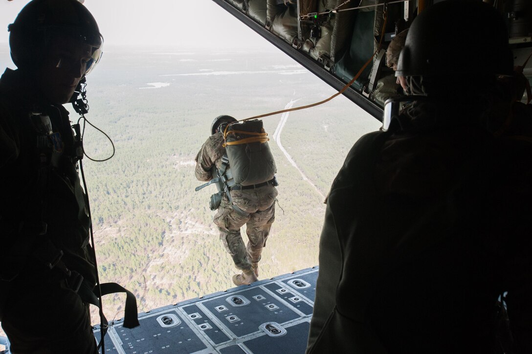 A paratrooper exits from the tailgate of an Air Force C-130 aircraft during a static-line parachute jump over a drop zone on Eglin Air Force Base, Fla., Jan 13, 2016. Army photo by Staff Sgt. William Waller