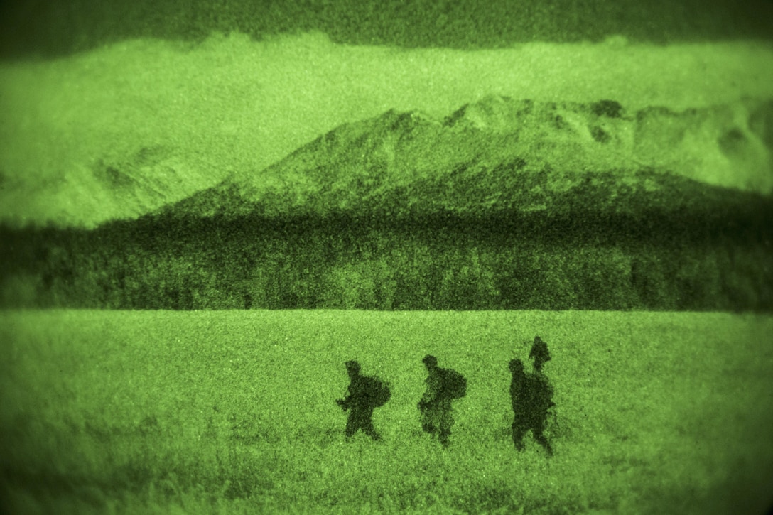 As seen through a night-vision device, U.S. and Canadian paratroopers proceed to the rally point after participating in a night jump onto Malemute drop zone on Joint Base Elmendorf-Richardson, Alaska, Jan. 21, 2016. U.S. Air Force photo by Alejandro Pena