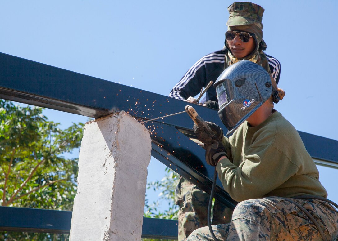 U.S. Marine Corps Cpl. Cami Snider, a Westerville, Ohio native, welds a tress onto a support column as Royal Thai Marine Corps Seaman Class Chainarong Kaewyongkot observes Jan. 23 at the Watkhunsong humanitarian civic action site, Chanthaburi, Thailand. The construction at Watkhunsong is one of six HCA sites in which the Thai, U.S. and partner nation’s militaries will work together on HCA programs to support security and humanitarian interests of friends and partner nations during Cobra Gold 2016. The programs will improve the quality of life, as well as the general health and welfare of civilian residents in the exercise areas. Snider is a metal worker with Marine Wing Support Squadron 172, Marine Aircraft Group 36, 1st Marine Aircraft Wing. Kaewyongkot is with the Engineer Battalion, Marine Division, Royal Thai Navy.