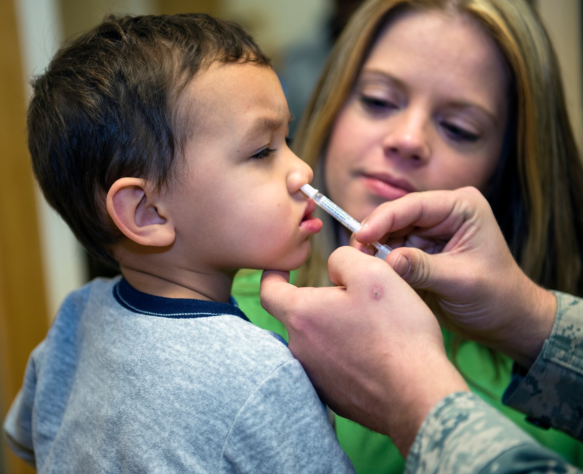 Tyson Gustin, son of Stacy and U.S. Air Force Staff Sgt. Michael Gustin, 23d Logistics Readiness Squadron, receives flu mist from a 23d Medical Operations Squadron allergy and immunization technician, Jan. 21, 2016, at Moody Air Force Base, Ga. During fiscal year 2015, the clinic administered approximately 17,000 vaccinations with an estimated 5,500 of those being flu vaccinations. (U.S. Air Force photo by Airman 1st Class Greg Nash/Released) 