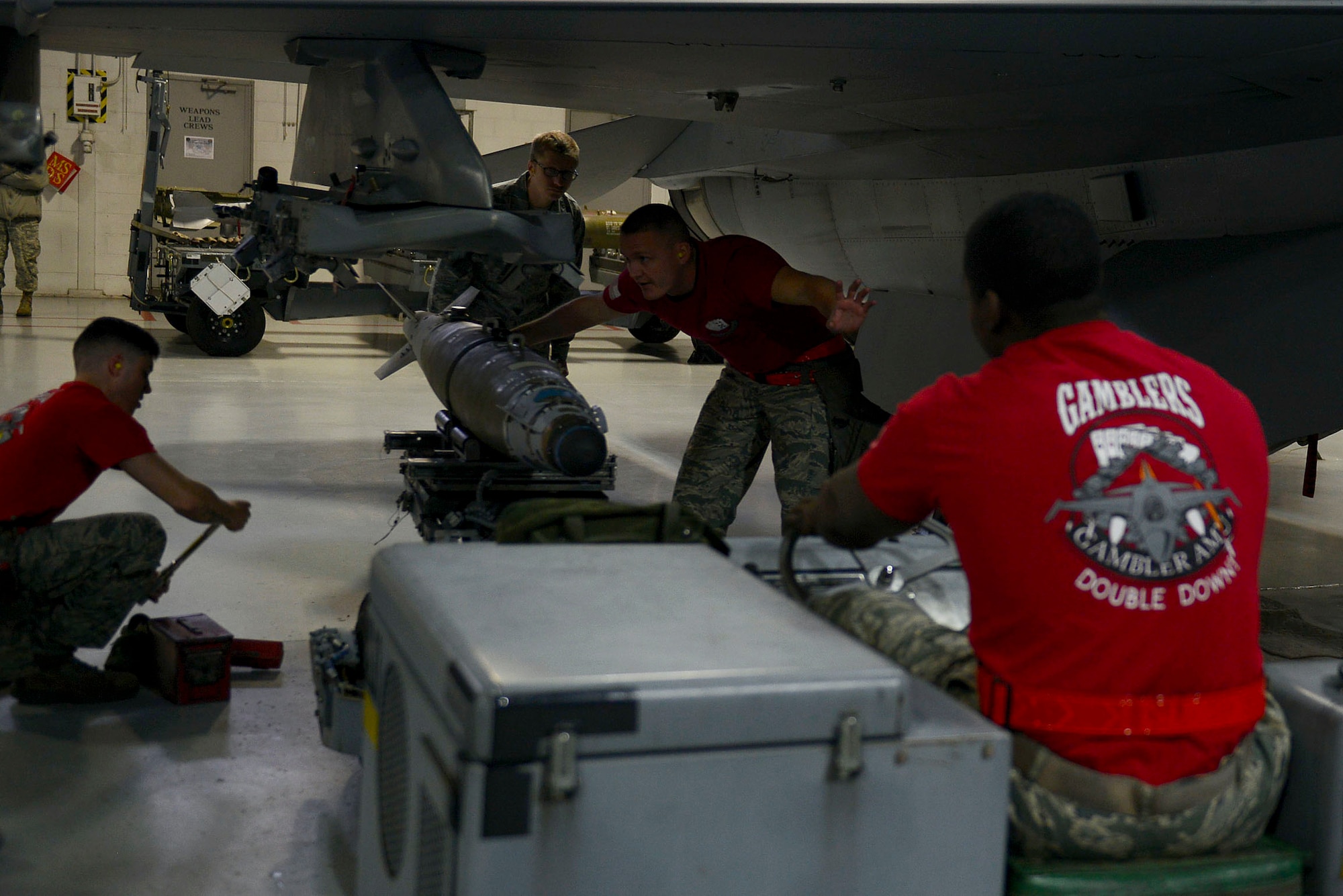 U.S Airmen assigned to the 20th Aircraft Maintenance Squadron, 77th Aircraft Maintenance Unit, work together to load a GBU-38 onto an F-16CM Fighting Falcon during a Load Crew of the Year competition at Shaw Air Force Base, S.C., Jan. 22, 2016. Load crews went head-to-head to see who could load munitions onto the F-16 most efficiently. (U.S. Air Force photo by Airman 1st Class Christopher Maldonado) 