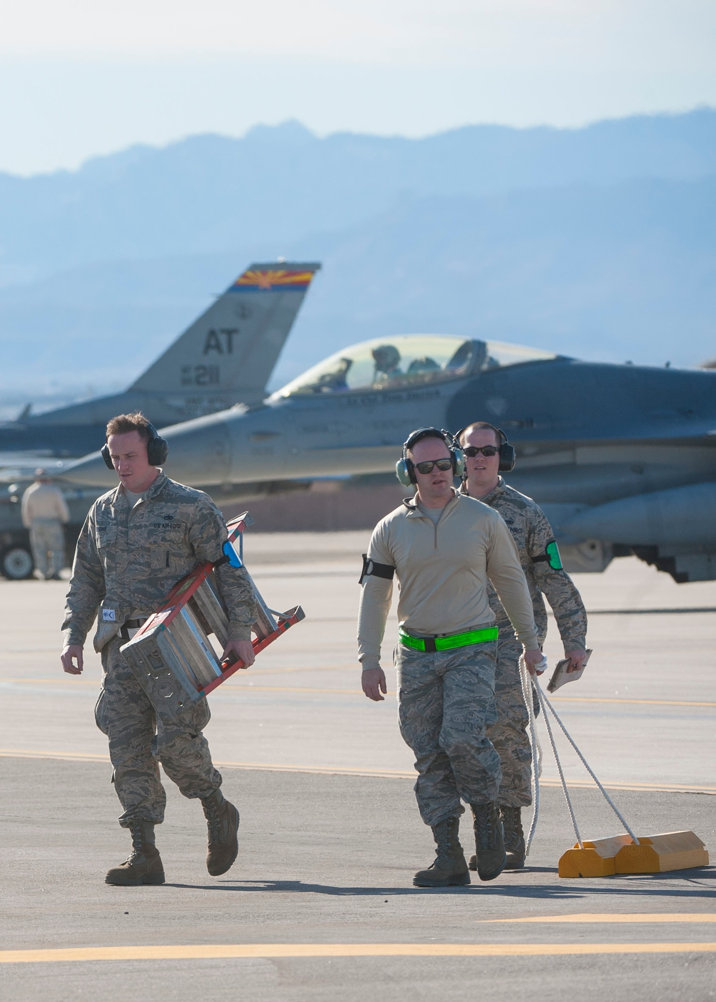 Crew members from Seymour Johnson Air Force Base, North Carolina, carry equipment away after working on an F-15E during Red Flag 16-1 at Nellis Air Force Base, Nev., Jan. 25, 2016. Red Flag is celebrating its 41st anniversary with Red Flag being a realistic combat training exercise involving the air, space and cyber forces of the U.S. and its allies, and is conducted on the vast bombing and gunnery ranges on the Nevada Test and Training Range. (U.S. Air Force photo by Senior Airman Jake Carter)