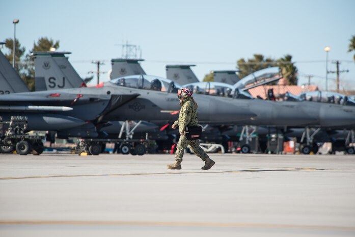 Maintainers from the U.S. Navy walk by F-15E Strike Eagles on the way to their jets at Nellis Air Force Base, Nev., Jan. 25, 2016, during Red Flag 16-1. All four branches of the military and coalition partners participate in Red Flag. The training is conducted to prepare forces to work together in future operations. (U.S. Air Force photo by Tech. Sgt. Christopher Holmes)