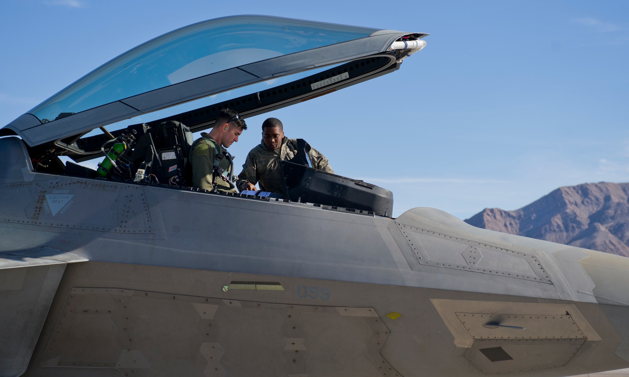 Major Scott Crowell, 325th Operations Group F-22 Raptor pilot, and Senior Airmen Eric Woods, 95th Aircraft Maintenance Unit crew chief, talk before Crowell takes flight on the first day of Red Flag 16-1, Jan. 25 at Nellis AFB, Nev. Integration is key at Red Flag, and Tyndall’s F-22s and Airmen join more than 130 aircraft and 3,000 personnel training during the exercise. (U.S. Air Force photo by Senior Airman Alex Fox Echols III/Released)  