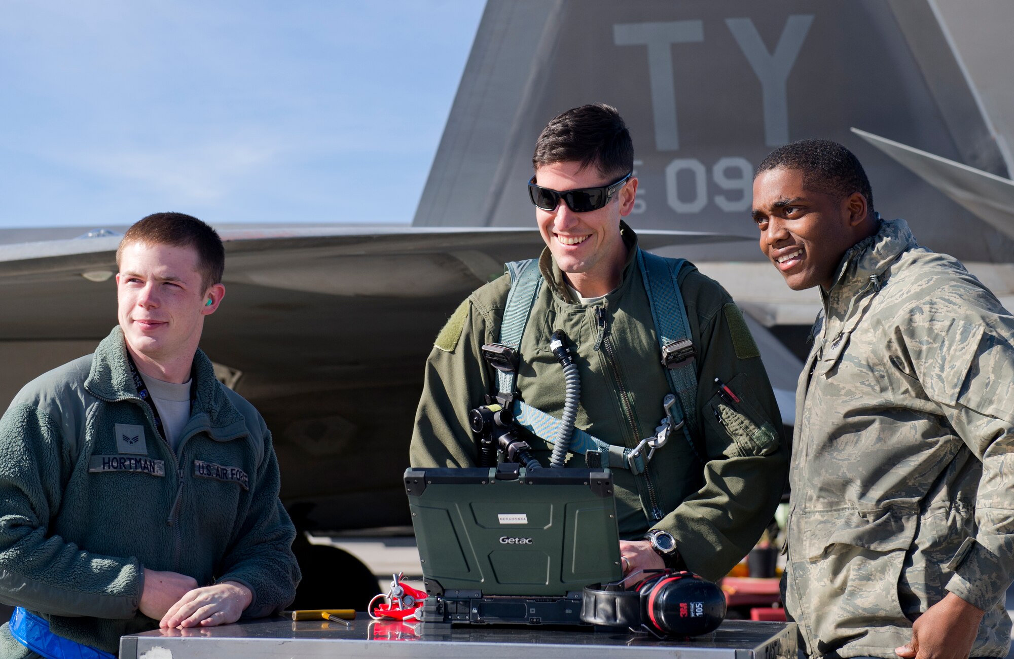 Major Scott Crowell, 325th Operations Group F-22 Raptor pilot, Senior Airmen Eric Woods, 95th Aircraft Maintenance Unit crew chief and Senior Airman Brandon Hortman, 95th AMU avionics specialist, talk on the flightline during the first day of Red Flag 16-1, Jan. 25 at Nellis AFB, Nev. Tyndall Airmen are honing their skills with three weeks of exercise training alongside squadrons from around the world. (U.S. Air Force photo by Senior Airman Alex Fox Echols III/Released)  