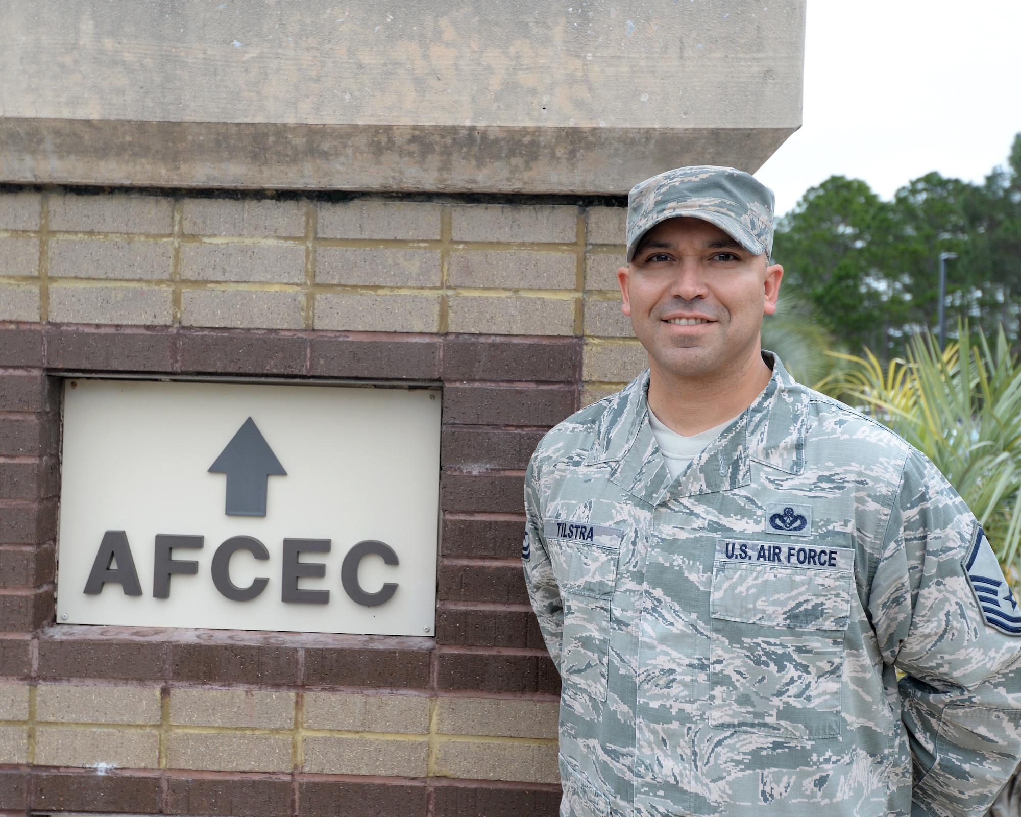 Master Sgt. Christopher Tilstra, AFCEC force development manager, poses next to the entrance of the Air Force Civil Engineer Center. AFCEC provides tools, practices and professional support to maximize Air Force civil engineer capabilities in base and contingency operations. The staff comprises technical and professional experts in a variety of areas including engineering, emergency management, training, pavement analysis, fire protection, explosive ordnance disposal, aircraft arresting systems, computer automation and energy management. (U.S. Air Force photo by Airman 1st Class Cody R. Miller/Released)