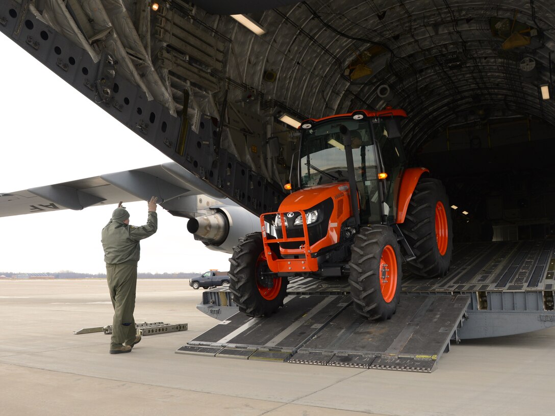 A tractor is loaded onto a C-17 Globemaster III at Niagara Falls Air Reserve Station, N.Y., January 9, 2016. The tractor is being transported to Dobbins Air Reserve Base. (Photo by U.S. Air Force Staff Sgt. Richard Mekkri/released)