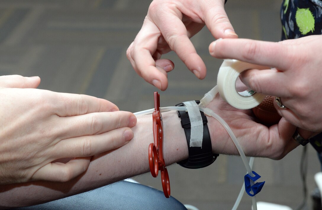 First Lt. Dillen Stuhlsatz, 34th Bomb Squadron weapons systems officer, donates blood in the Deployment Center sterile room at Ellsworth Air Force Base, S.D., Jan. 22, 2016. Blood donation is a simple four-step process: registration, medical history and mini-physical, donation and refreshments, and provides live-saving blood for patients in the area. A simple pint of blood can potentially save three lives. (U.S. Air Force photo by Airman Donald C. Knechtel/Released)