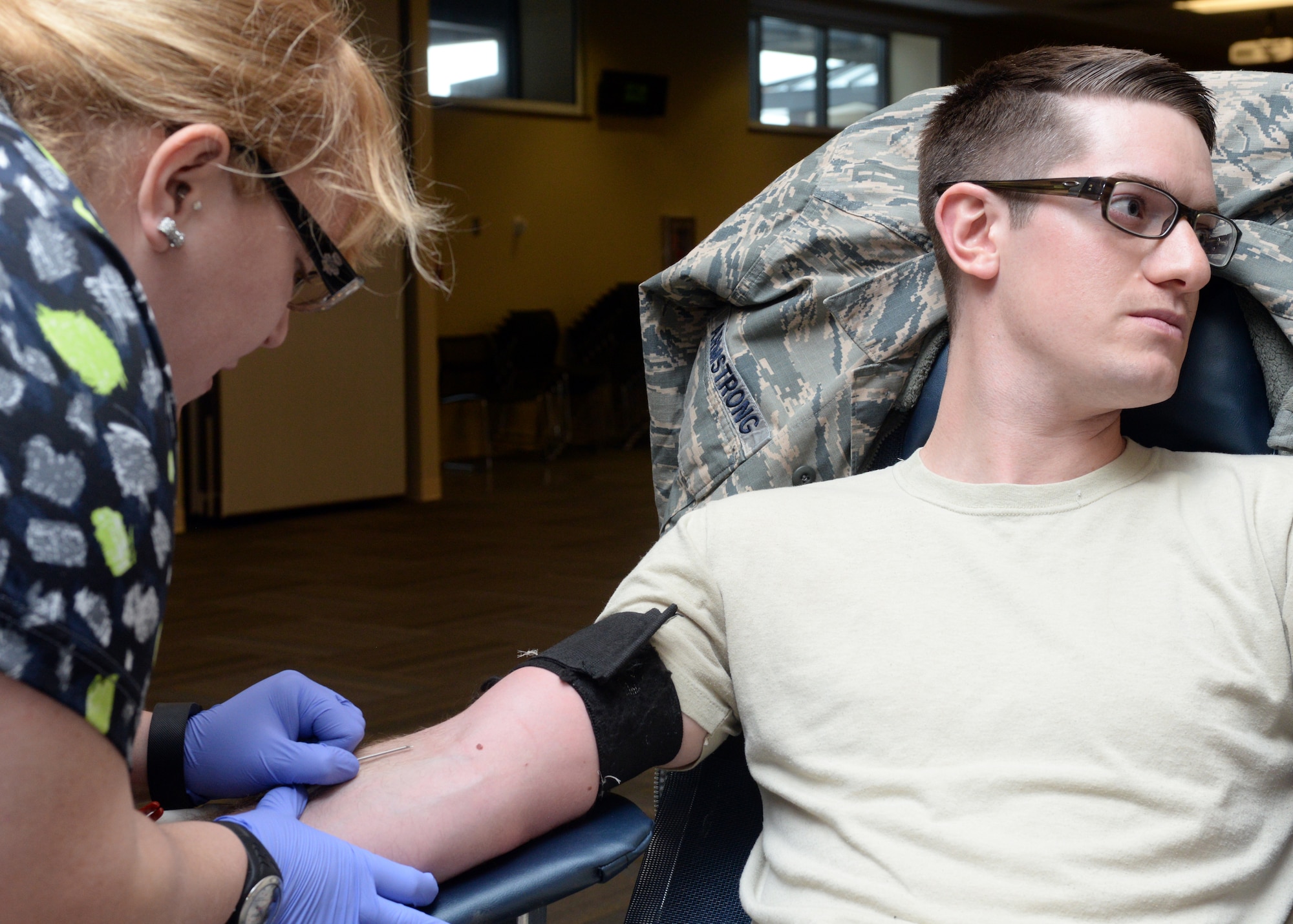 Staff Sgt. Jacob Armstrong, 28th Maintenance Group deficiency analyst, donates blood in the Deployment Center sterile room at Ellsworth Air Force Base, S.D., Jan. 22, 2016. Each volunteer gives a pint of blood, taking five to 10 minutes to donate. During the six hour donation drive on base, United Blood Services personnel successfully collected 44 pints of blood. (U.S. Air Force photo by Airman Donald C. Knechtel/Released)