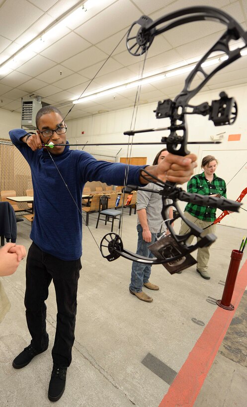 Airman 1st Class Daquanne McDowell, 28th Force Support Squadron commander support staff, draws an arrow during a Dinner and a Bow event in the archery range at Ellsworth Air Force Base, S.D., Jan. 22, 2016. The event was held by the base’s Outdoor Recreation Center to promote morale and foster socialization amongst Airmen. (U.S. Air Force photo by Airman Sadie Colbert/Released)