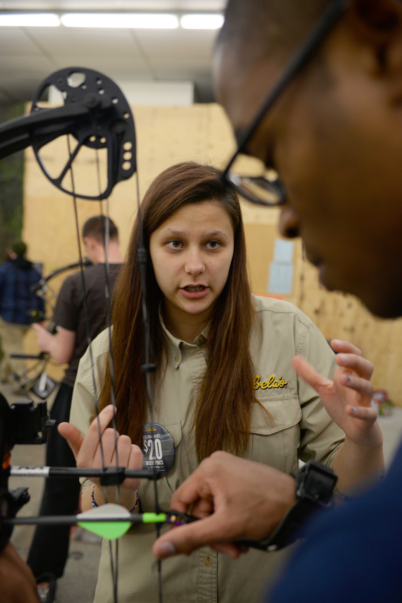 Aspin Pitcher, Cabela’s archery technician, shows Airman 1st Class Daquanne McDowell, 28th Force Support Squadron commander support staff, how to use a compound bow during a Dinner and Bow event at Ellsworth Air Force Base, S.D., Jan. 22, 2016. The event gave Airmen a chance to enjoy free pizza while learning how to use various bows and archery components. (U.S. Air Force photo by Airman Sadie Colbert/Released)