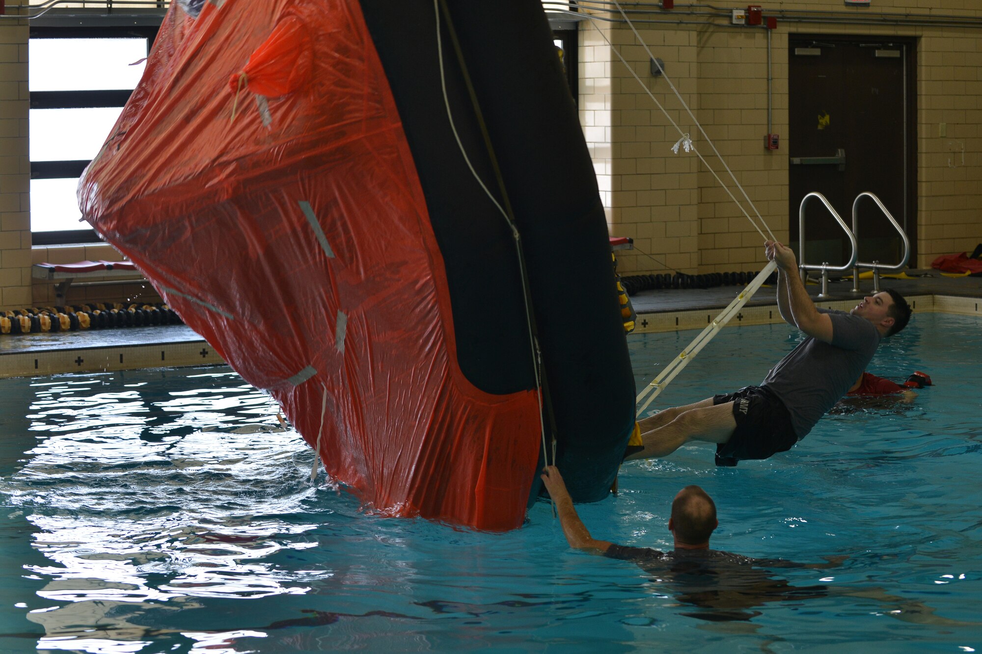 U.S. Army Spc. Skylar Birkhimer, a watercraft operator student with the Maritime Intermodal Training Department, turns a 25-person life raft right side up during a survival swimming training at Fort Eustis, Va., Jan. 26, 2016. The training allowed for students to practice not only life-raft procedures, but drown-proofing skills without the raft. (U.S. Air Force photo by Staff Sgt. Natasha Stannard)