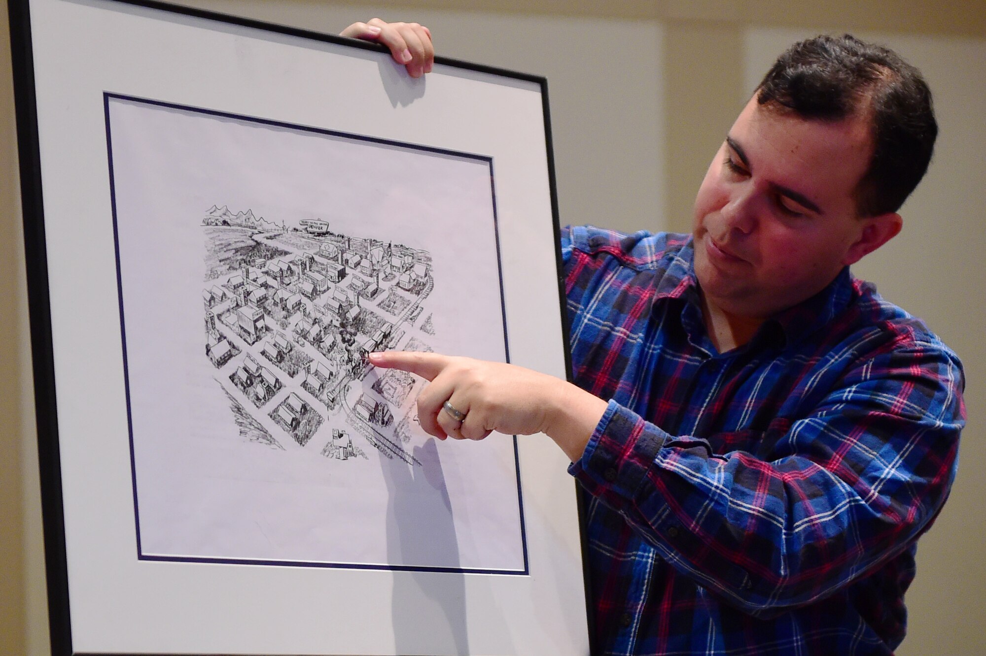 Christopher McCune, 460th Space Wing historian, shows a historical base map to students from William Smith High School at the Leadership Development Center Jan. 27, 2016, on Buckley Air Force Base, Colo. The group of students visited Buckley AFB to learn about the base’s impact during World War II. (U.S. Air Force photo by Senior Airman Racheal Watson/Released)