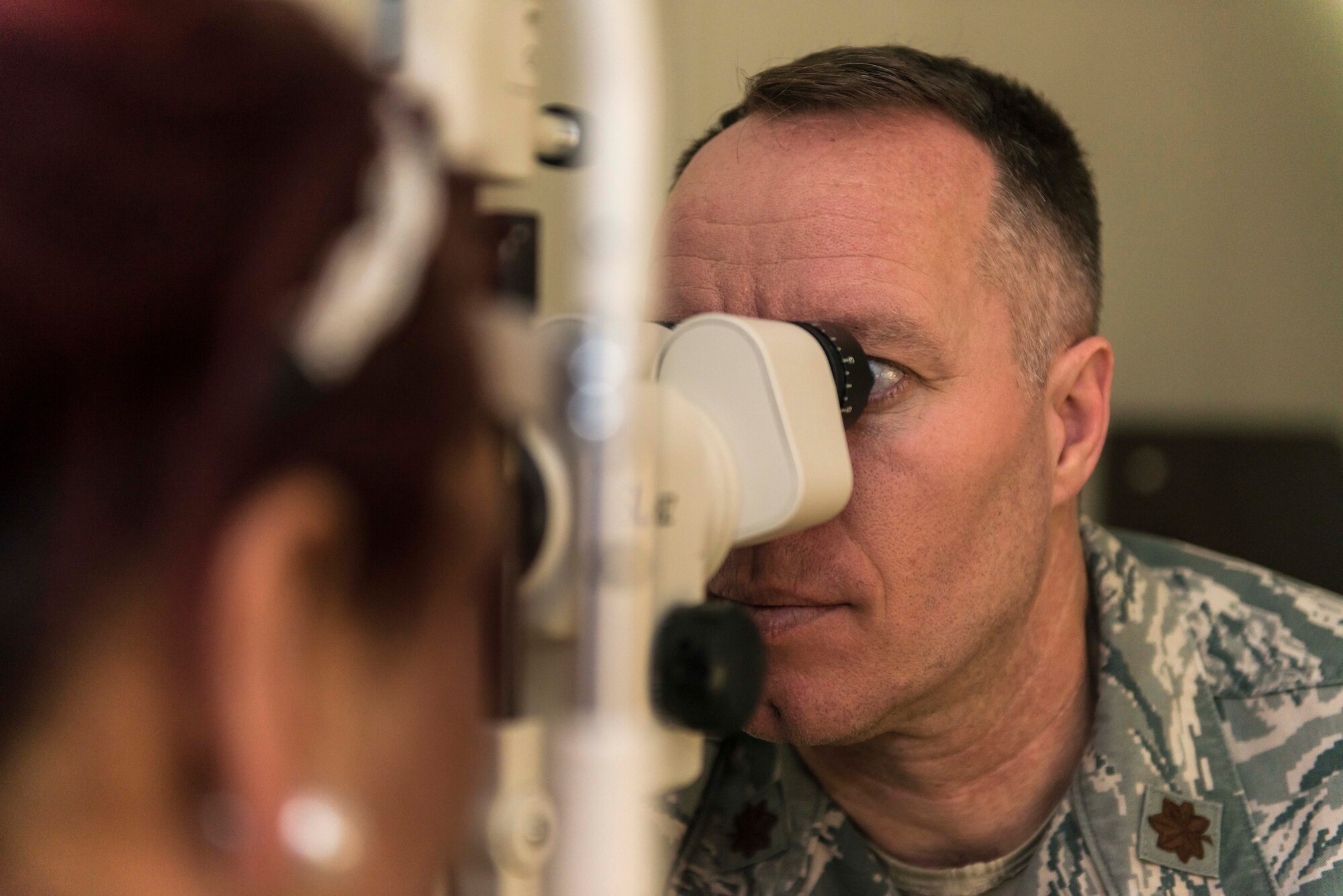 U.S. Air Force Maj. Ronny Bowman, an optometric physician with the 35th Aerospace Medicine Squadron, examines the eyes of Tina Rueb, a child youth program assistant with the Lunney Youth Center, at Misawa Air Base, Japan, Jan. 21, 2016. The physician looks for an array of different symptoms including signs of astigmatism, floaters and general retinal health. Bowman hails from Paris, Arkansas, and Reub is a Clovis, New Mexico, native. (U.S. Air Force photo by Staff Sgt. Benjamin W. Stratton)