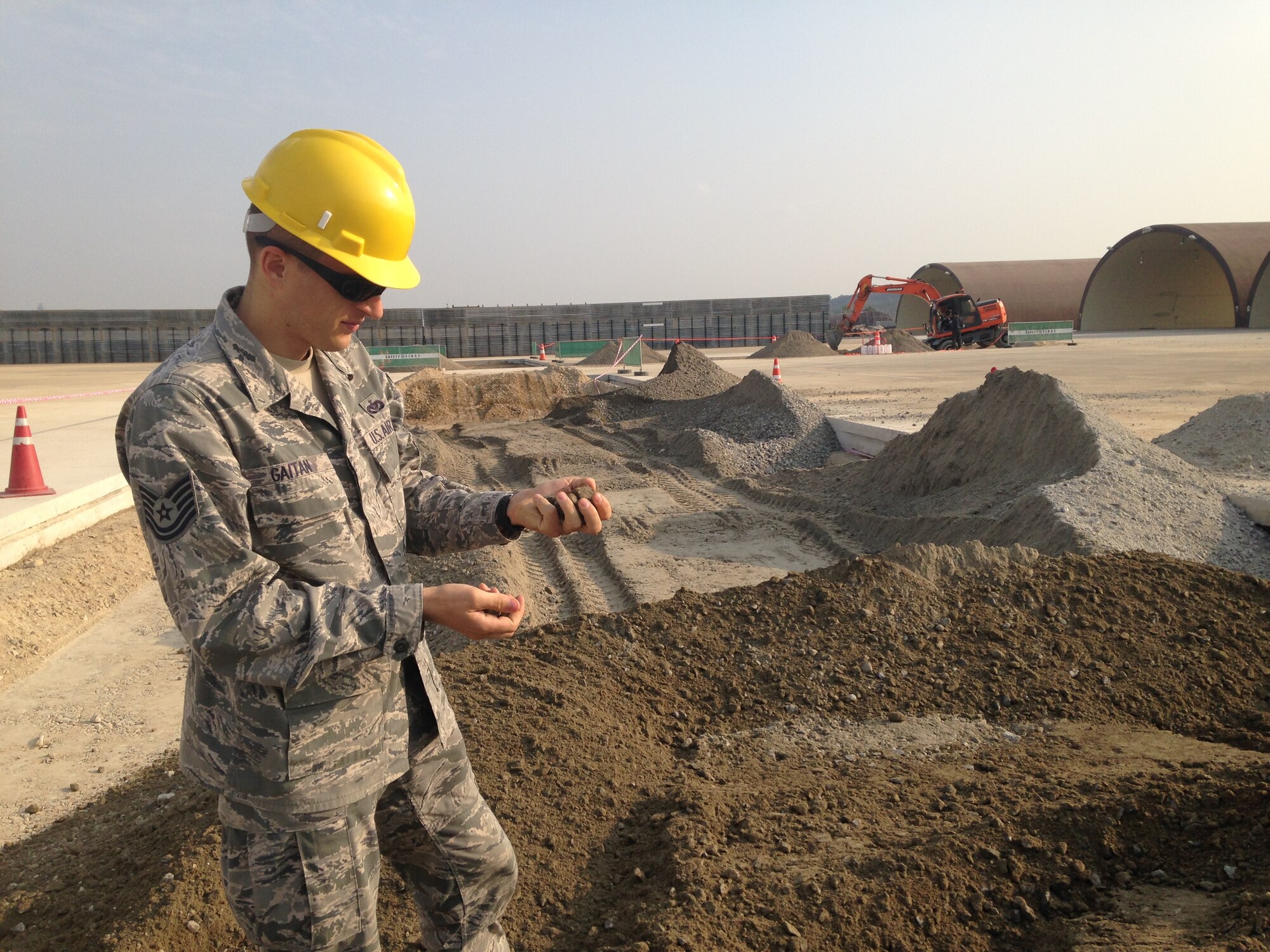 Tech. Sgt. Ioan Gaitan, 607th Materiel Maintenance Squadron, noncommissioned officer in charge of engineering support, inspects aggregate brought on site for an airfield project at Suwon Air Base, Republic of Korea.  His job encompasses managing multi-million-dollar contracts and supporting over 600 tenant soldiers living and operating out of the facilities that the Air Force maintains at Suwon AB.  Gaitan was recently selected for Officer Training School building on an exemplary enlisted career, one he couldn’t have imagined when nine years ago he was randomly selected for a diversity immigrant visa allowing him to leave his home country of Romania and live, study and work freely in the United States.  (Courtesy photo)