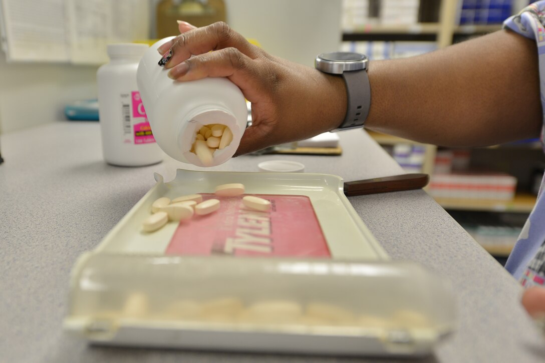 Catrina Shepard, a pharmacy technician at the McDonald Army Health Center first floor pharmacy, counts medication at Fort Eustis, Va.,  Jan. 25, 2016. The pharmacy also utilizes automated systems that count and label medications, increasing delivery time and saving manpower. (U.S. Air Force photo by Staff Sgt. Stannard)
