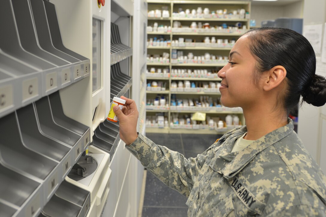 U.S. Army Spc. Isabelrosamaria Muna, a pharmacy technician at the McDonald Army Health Center first floor pharmacy, retrieves medication from the automated label machine at Fort Eustis, Va., Jan. 25, 2016. The pharmacy serves approximately 600 patients daily and aims to complete their transactions within 30 minutes. (U.S. Air Force photo by Staff Sgt. Stannard)