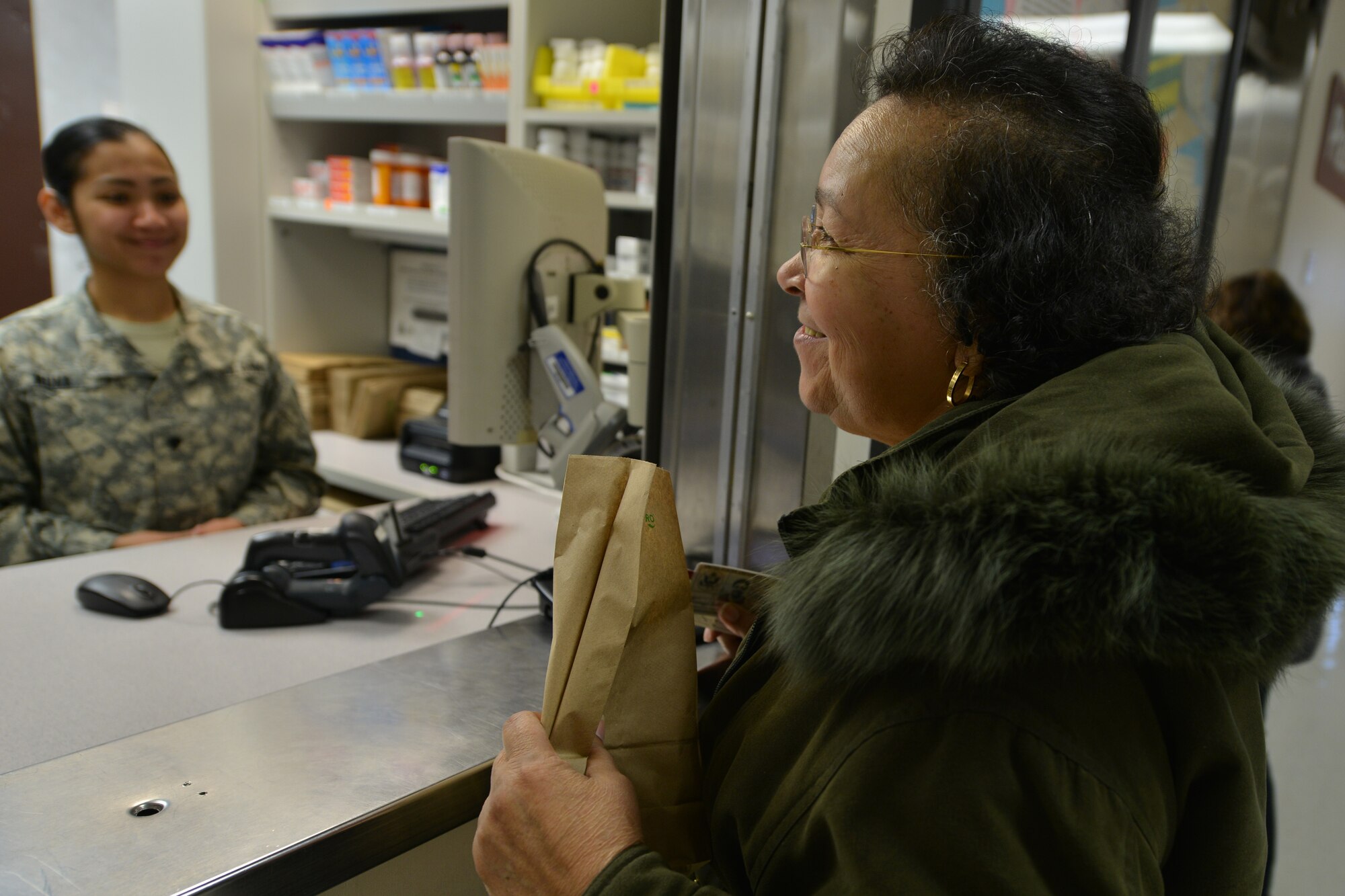 Earsey Rodrigues, a McDonald Army Health Care first-floor pharmacy customer, asks a pharmacist and technician questions about her medications at Fort Eustis, Va., Jan. 26, 2016. Before administering medication, pharmacists meet with the technicians to verify the prescription is accurately filled. (U.S. Air Force photo by Staff Sgt. Stannard)